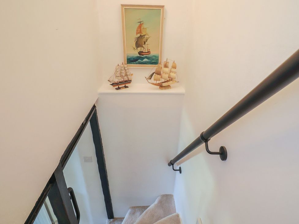 A staircase with sailing ship decor at Mei's Cottage in Pinhoe