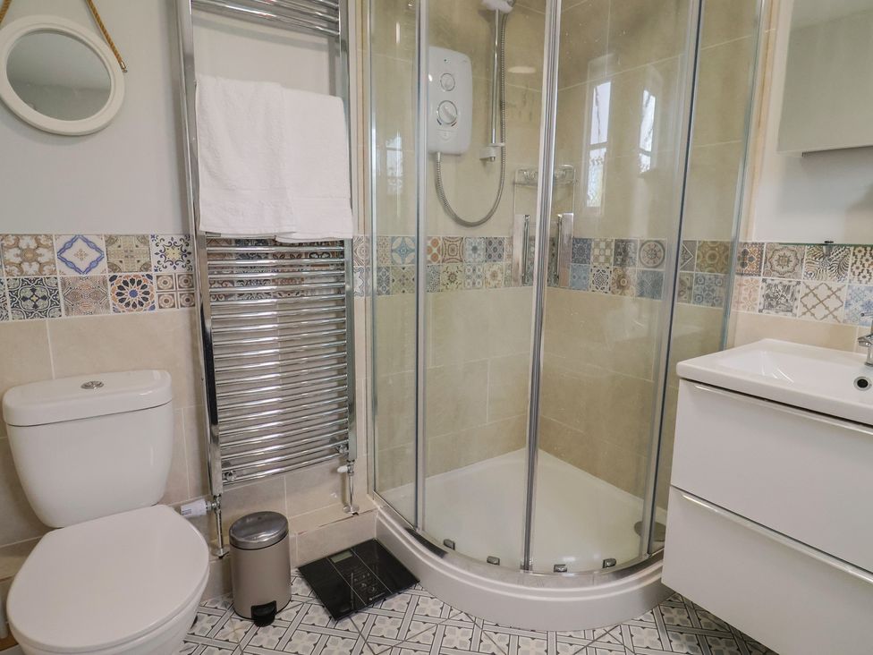 A bathroom with a shower and sink at Mei's Cottage in Pinhoe