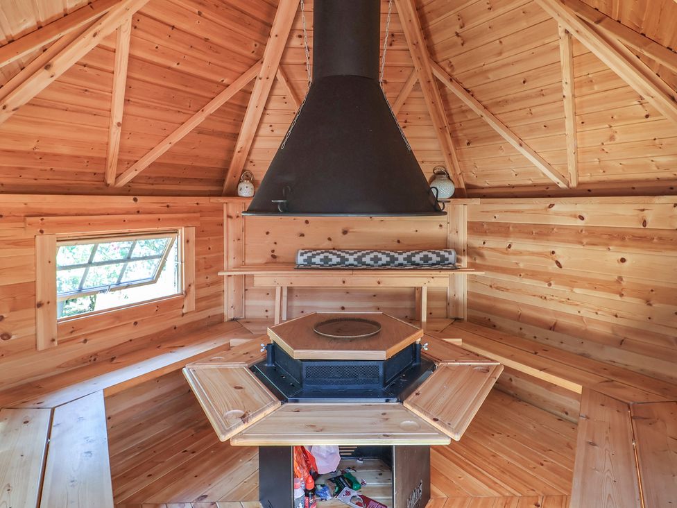 An indoor space with wooden walls and a fireplace at Mei's Cottage in Pinhoe