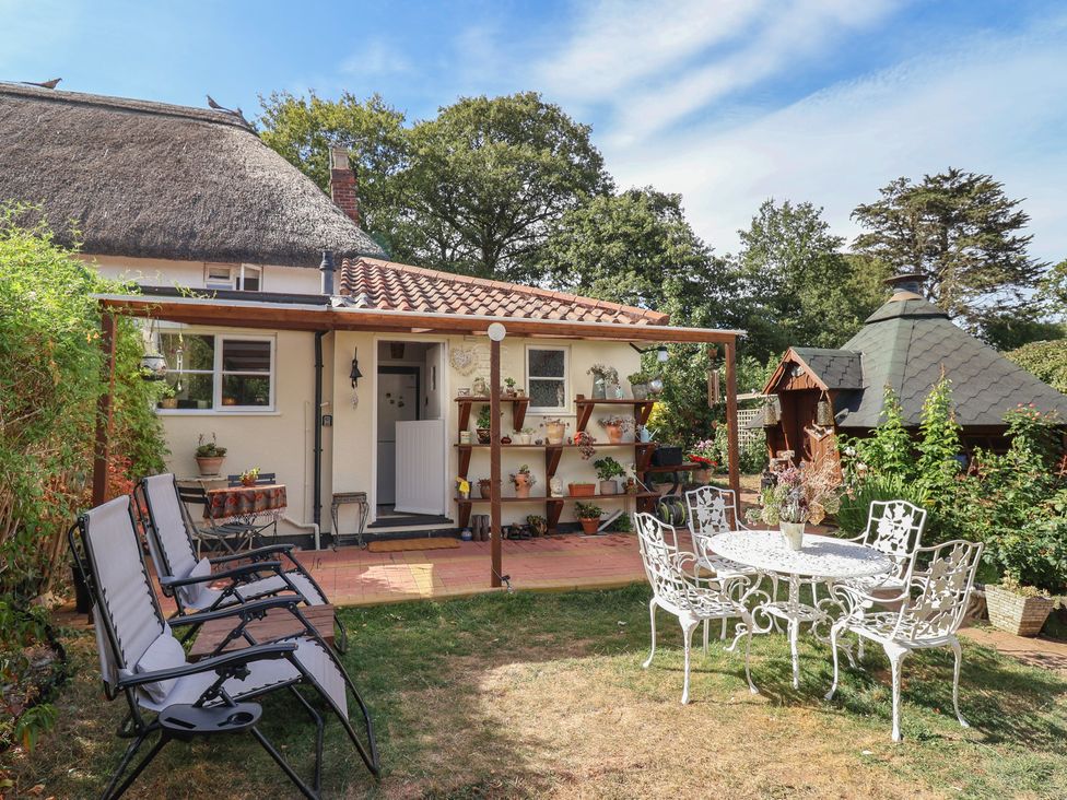 A garden with chairs and a table at Mei's Cottage in Pinhoe