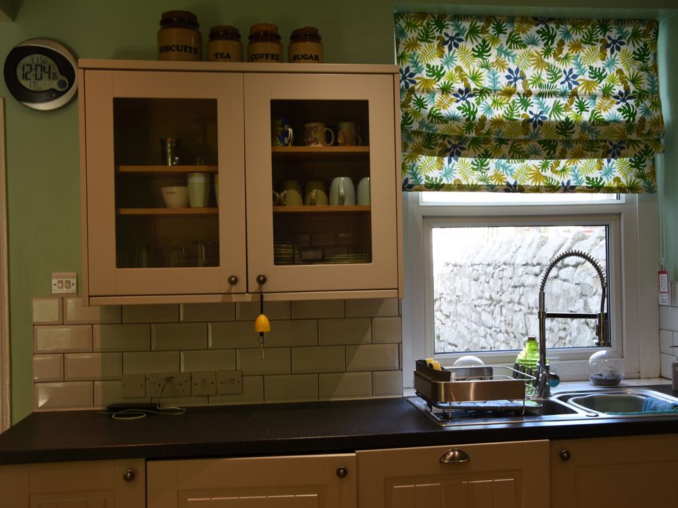 A kitchen with cabinets and a sink at 33 High Street in Fortuneswell