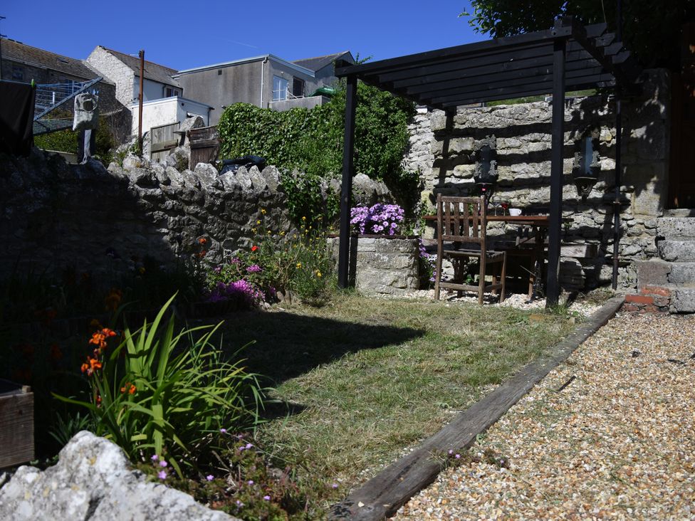 A garden with a table and chairs at 33 High Street Fortuneswell