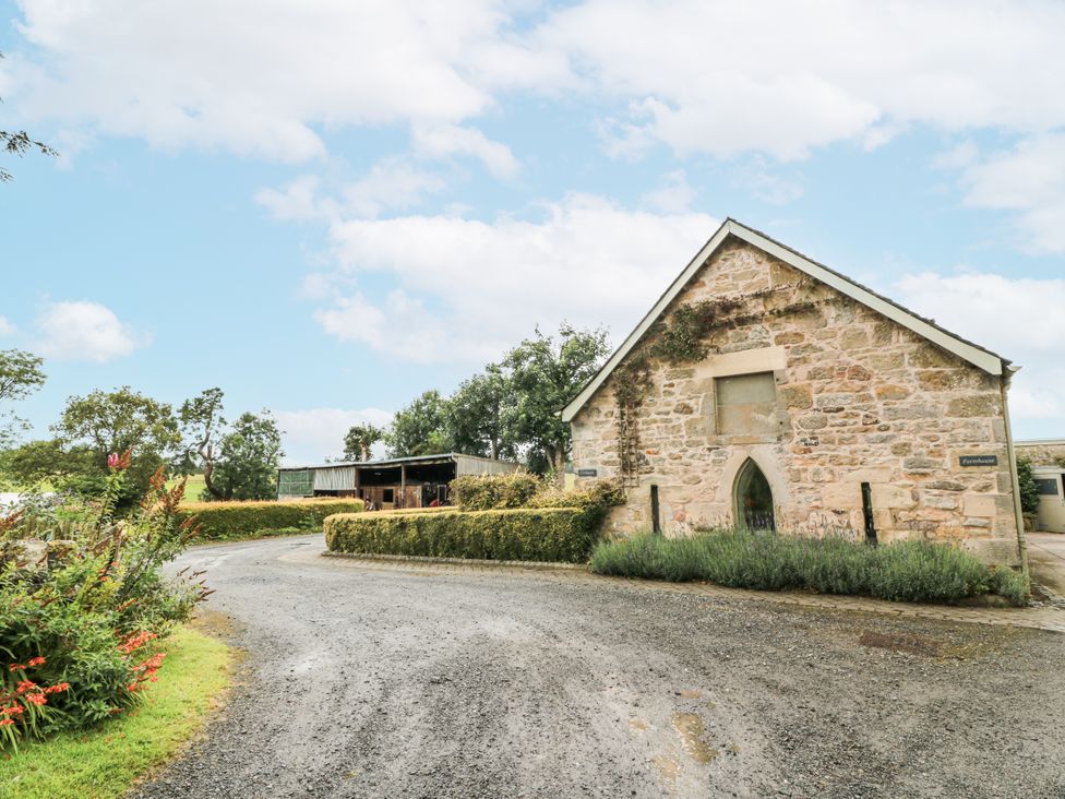A building with a stone facade and a road leading to it at Thorneydyke Cottage in Stirling