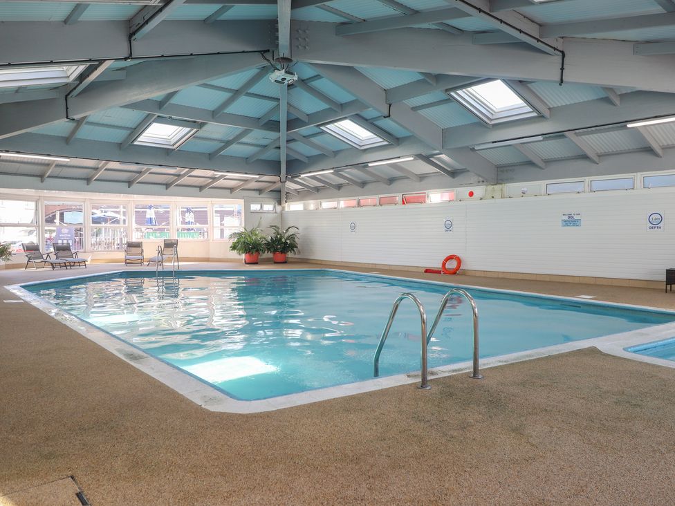 An indoor pool area with a swimming pool and deck chairs at Tamar View Lodge in Millbrook