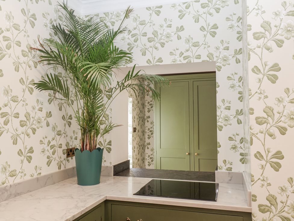 A kitchen with a palm plant on a marble countertop at Syleham House Syleham near Eye