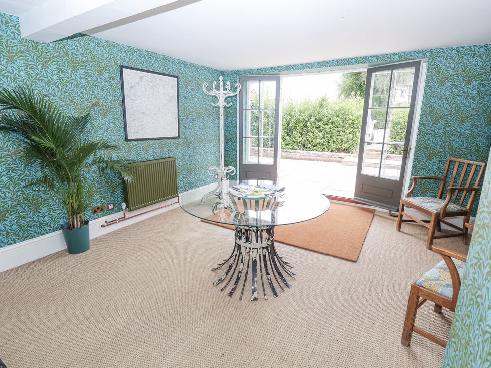 A snug with a table and chairs at Syleham House in Syleham near Eye