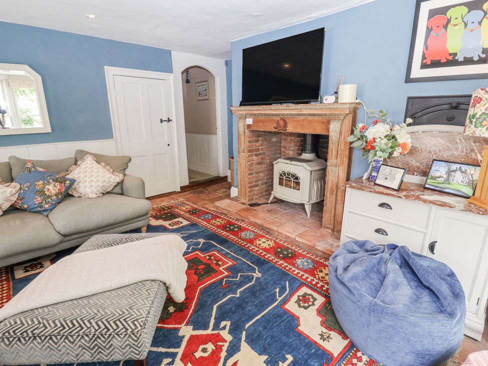 A living room with a fireplace and sofa at Syleham House in Syleham near Eye