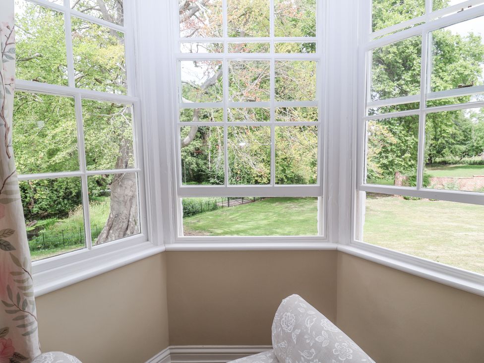 A sunroom with windows overlooking a garden at Syleham House in Syleham near Eye