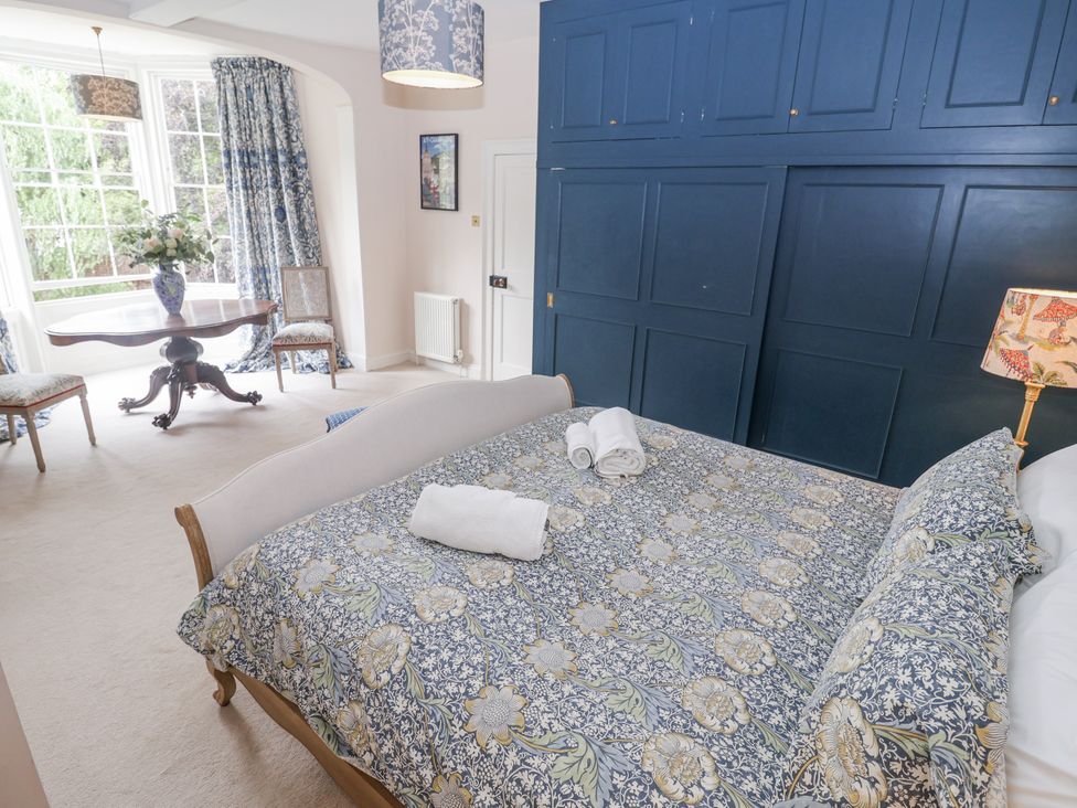 A bedroom with a bed and a small table at Syleham House Syleham near Eye