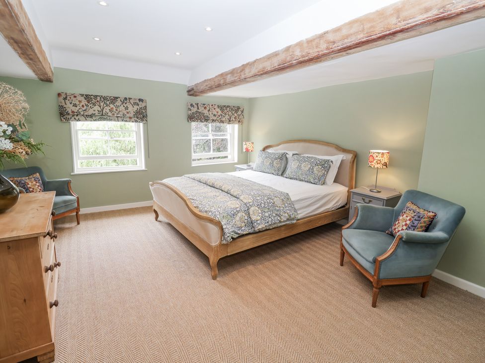 A bedroom with a bed and a chair at Syleham House in Syleham near Eye
