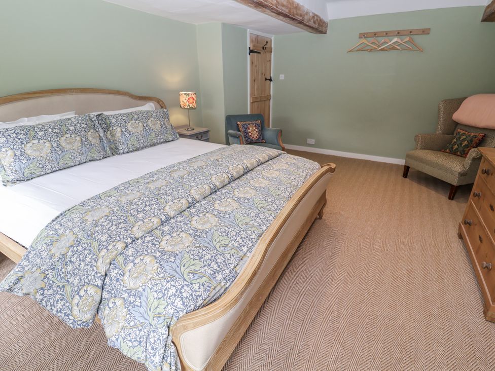 A bedroom with a bed and armchair at Syleham House Syleham near Eye
