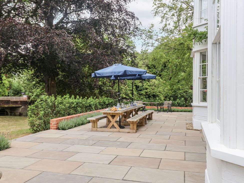 An outdoor patio with a table and umbrella at Syleham House Syleham near Eye