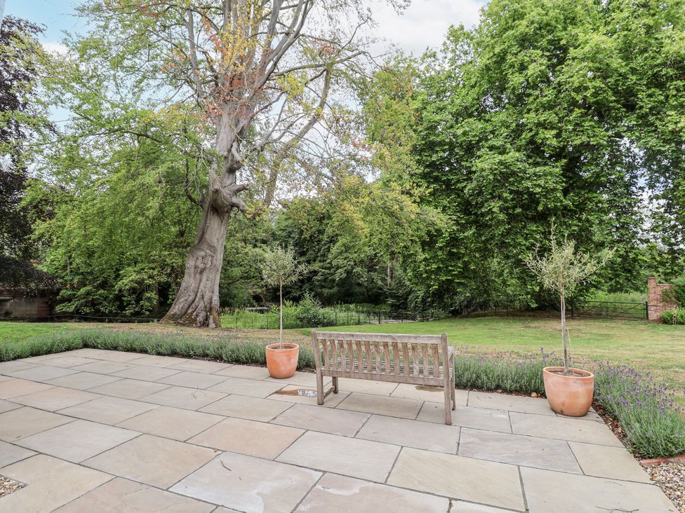 A garden with a bench and trees at Syleham House in Syleham near Eye
