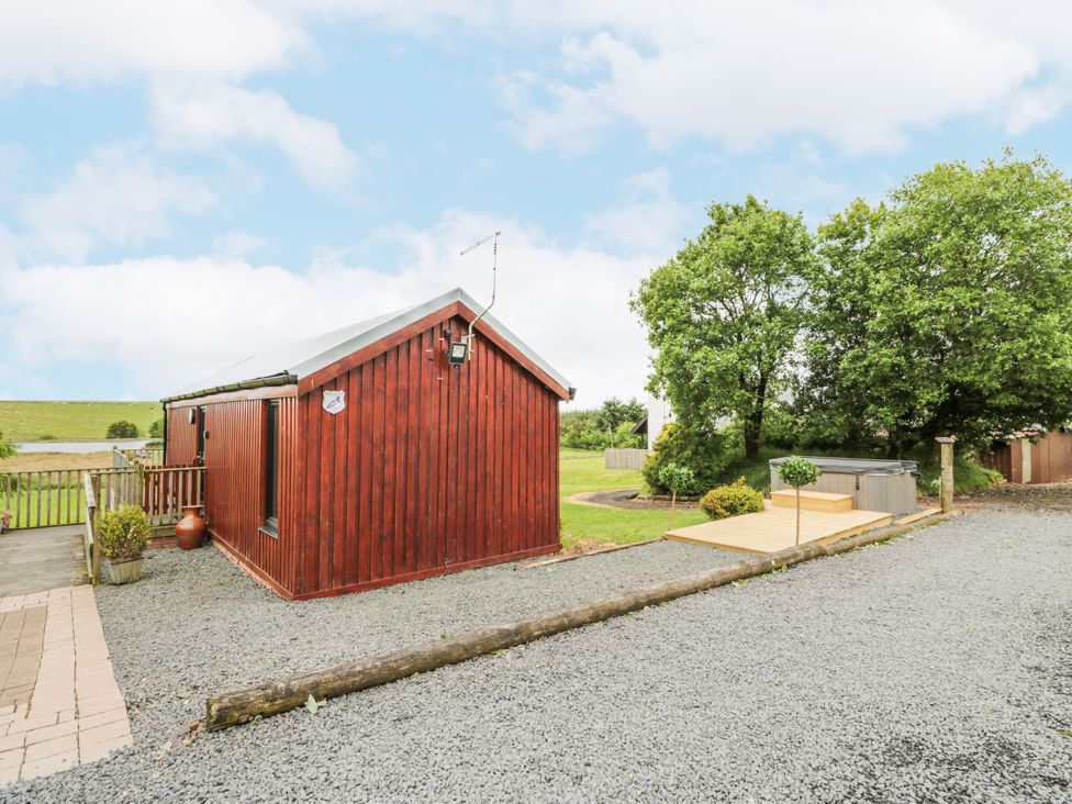 A cabin with a hot tub and deck in the outdoor area at Mallard Lodge in Moscow near Galston