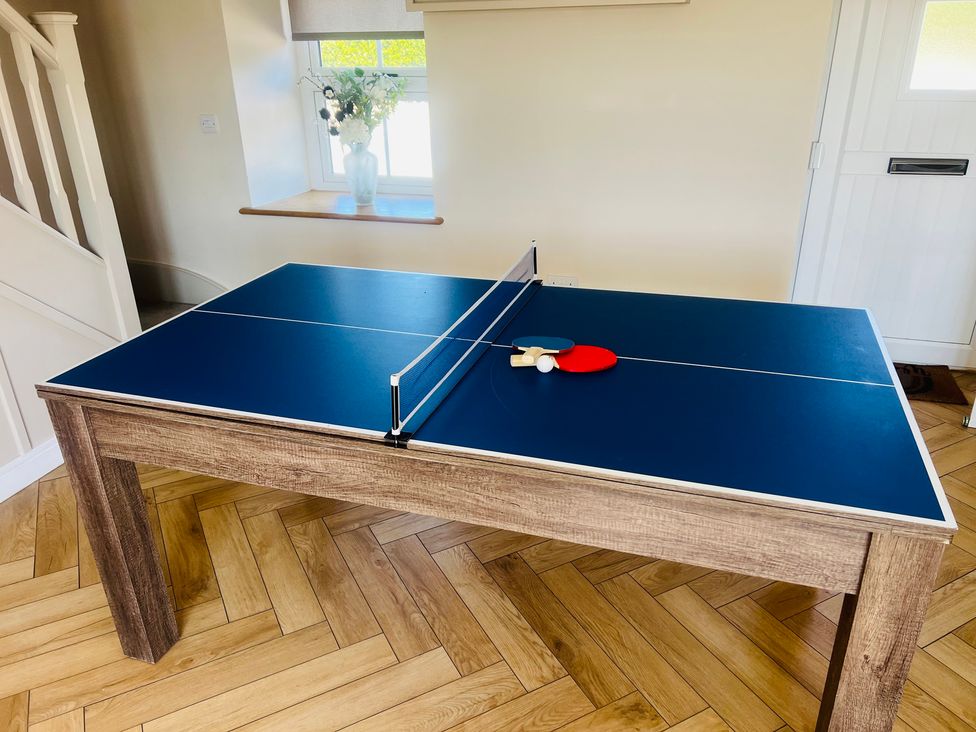 A ping pong table with paddles and a ball at Rhos Las in Cerrigydrudion
