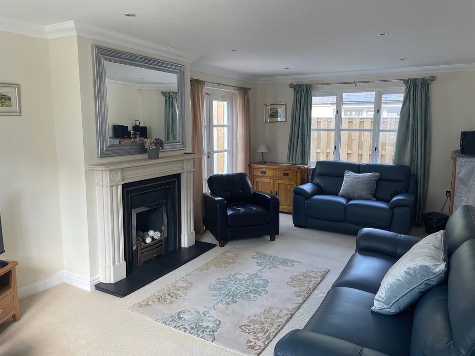 A living room with a fireplace and seating area at 3 Strawberry Close Little Haven near Broad Haven