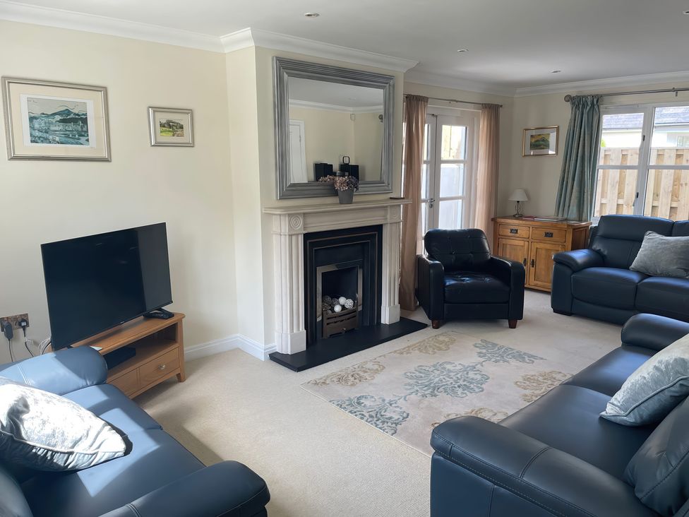 A living room with a fireplace and television at 3 Strawberry Close Little Haven near Broad Haven