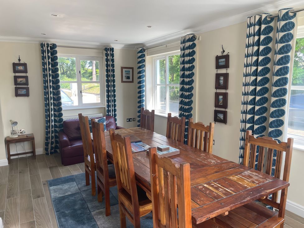 A dining room with a wooden table and chairs at 3 Strawberry Close Little Haven near Broad Haven