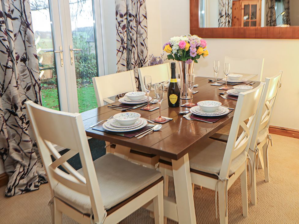 A dining area with a table set for a meal at The Beeches in Aldwark near Winster