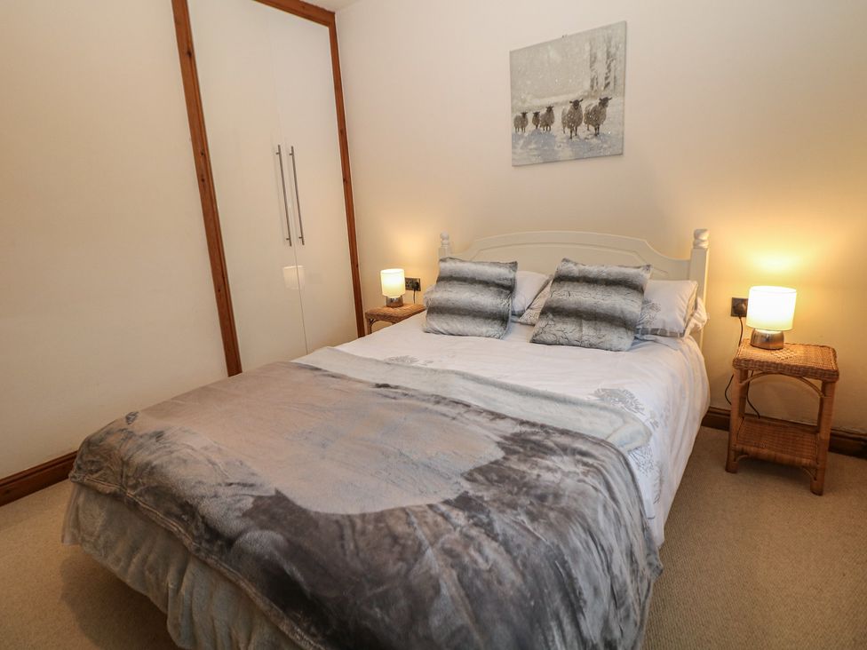 A bedroom with a bed and two bedside lamps at The Beeches in Aldwark near Winster