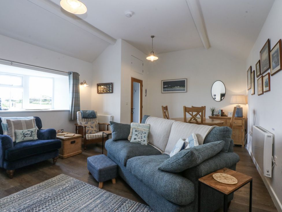 A living room with a sofa and armchair at Bwthyn Y Swnt in Moelfre