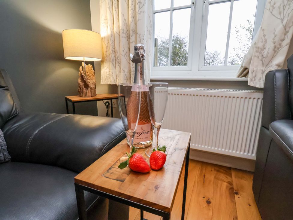 A table with a bottle of champagne and glasses in the living room at The Beach Retreat The Bay - Filey
