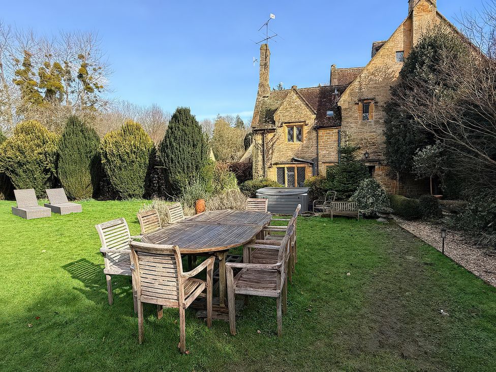 A garden with a wooden table and chairs at King Ina's Palace in South Petherton