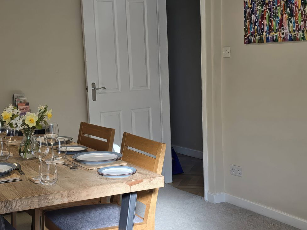 A dining room with a table set for meals at Bay Tree Cottage in Keswick