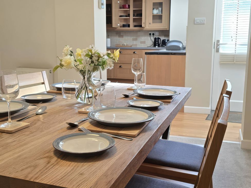 A dining room with a table set for a meal at Bay Tree Cottage in Keswick