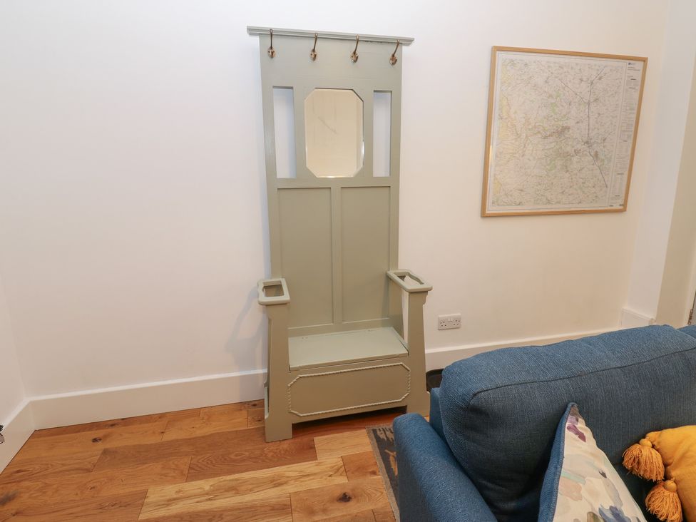 A coat rack and sofa in a living room at Bay Tree Cottage in Richmond