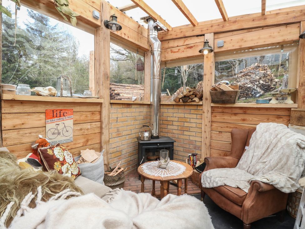A snug with a stove and seating area at The Cottage In The Woods, Connel, Argyll & Bute