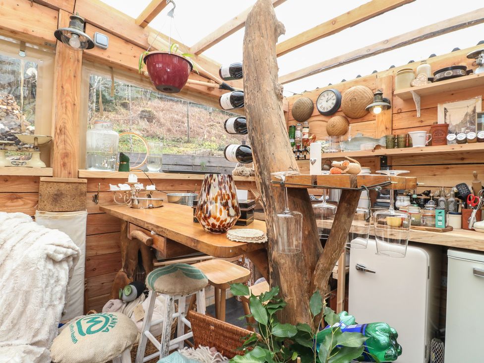 A kitchen with wooden furniture and various kitchenware at The Cottage In The Woods, Connel, Argyll & Bute