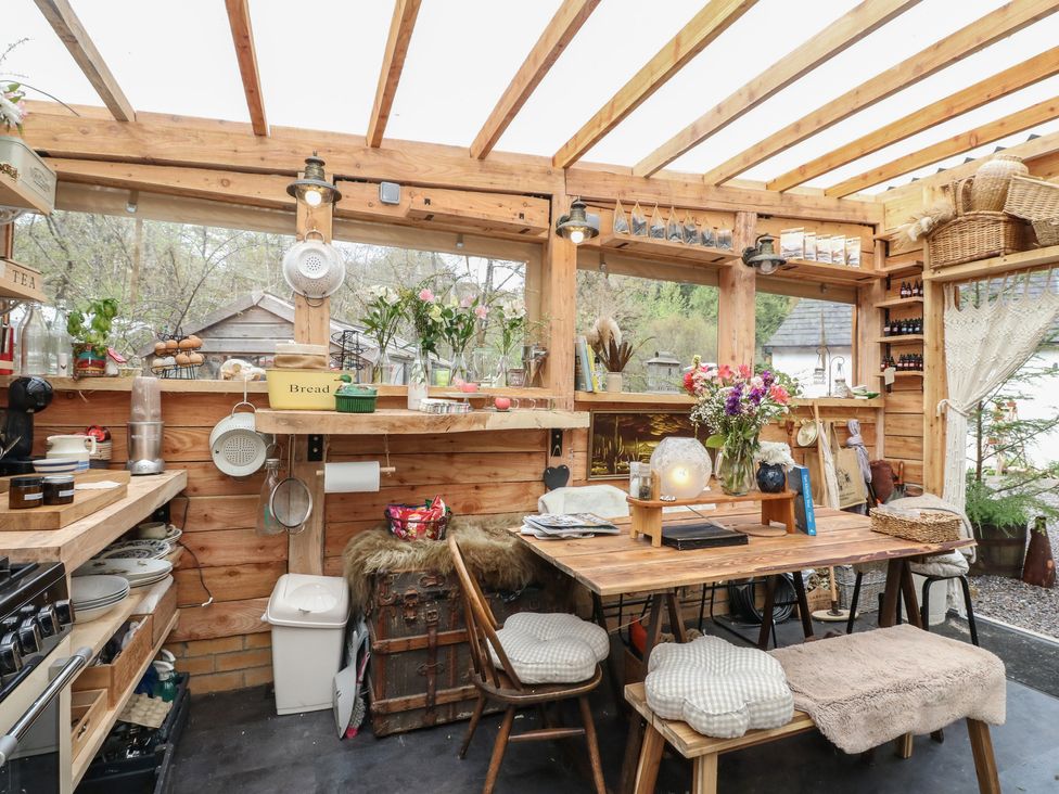 A kitchen with wooden beams and a table at The Cottage In The Woods Connel, Argyll & Bute