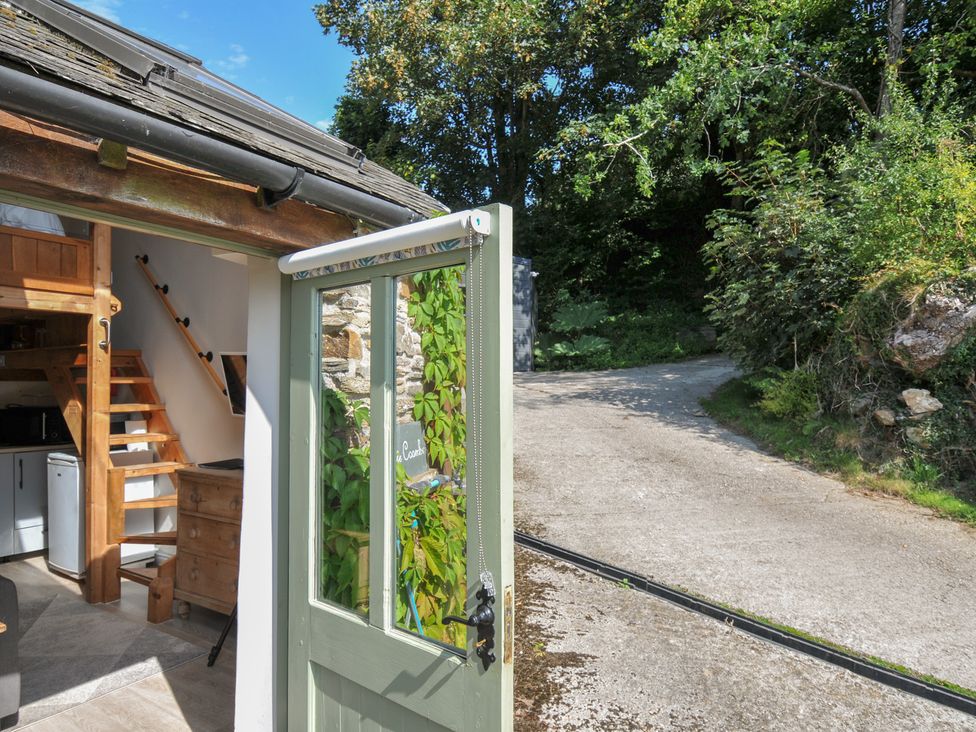 A doorway showing a staircase and shelving at Little Coombe Trehunist near Liskeard