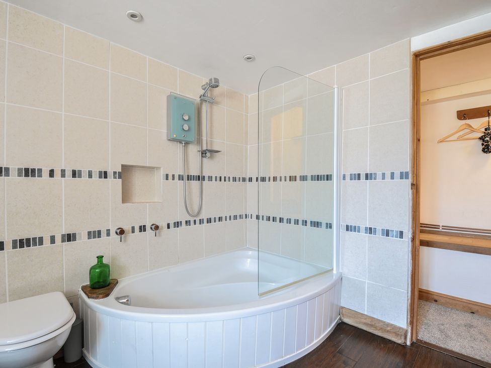 A bathroom with a bathtub, shower and toilet at Little Coombe in Trehunist near Liskeard