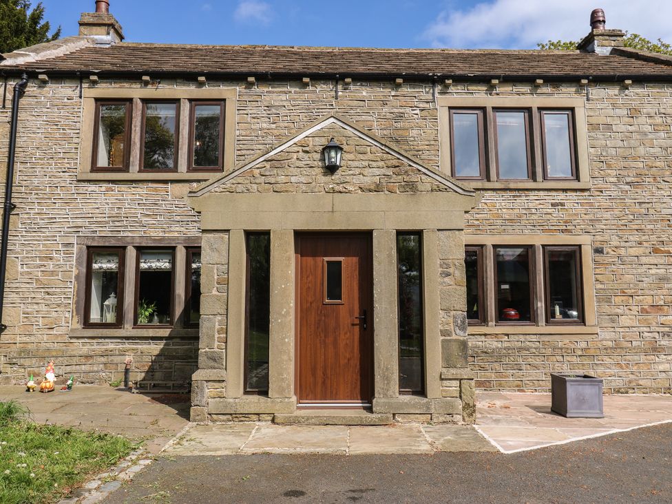 A house exterior with stone walls and a wooden door at Stagwood House in New Mill