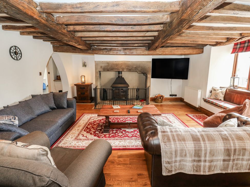 A living room with a fireplace and sofas at Stagwood House in New Mill