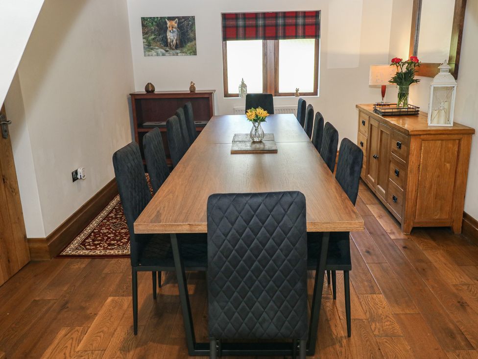 A dining room with a large table and chairs at Stagwood House in New Mill