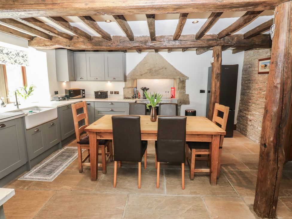 A kitchen with a table and chairs at Stagwood House in New Mill