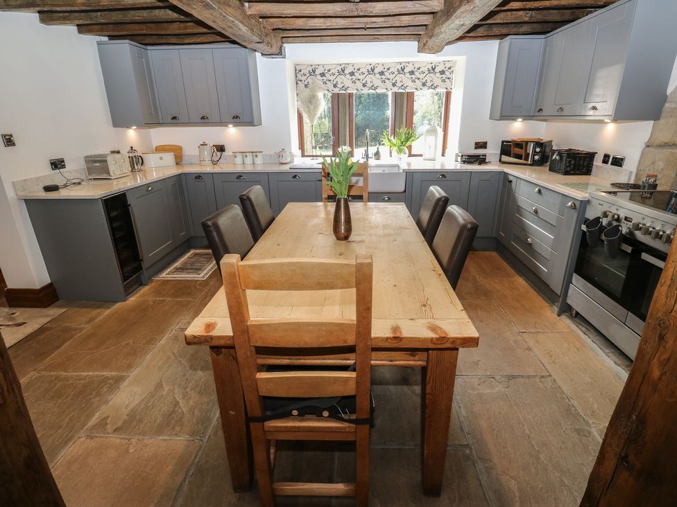A kitchen with a wooden table and chairs at Stagwood House in New Mill