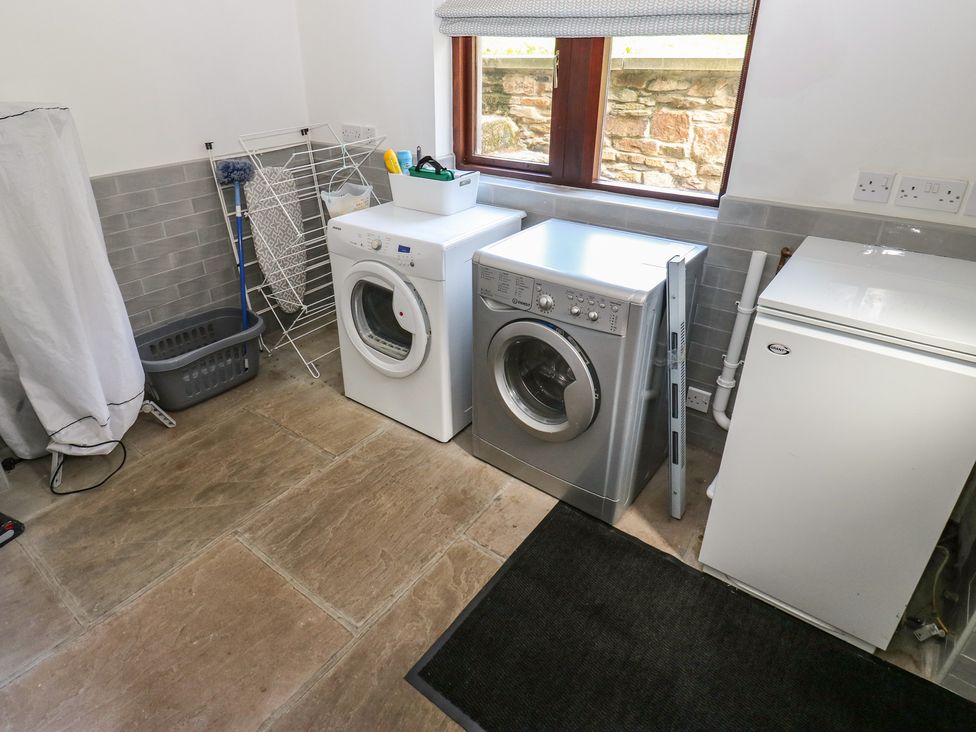 A laundry room with a washing machine and dryer at Stagwood House in New Mill