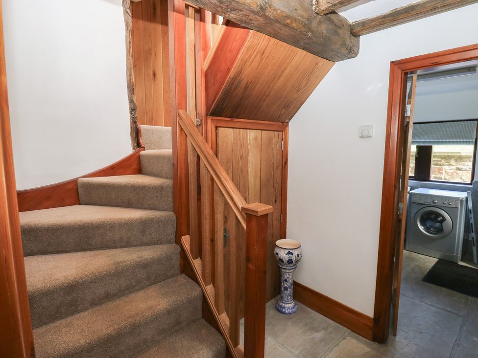 A hallway with a staircase and a washing machine at Stagwood House New Mill