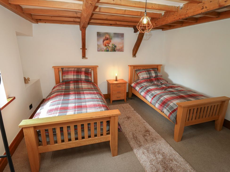 A bedroom with two single beds and a bedside table at Stagwood House New Mill