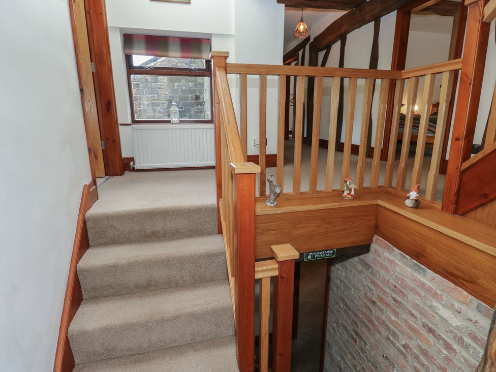 A staircase with wooden handrail and window at Stagwood House New Mill