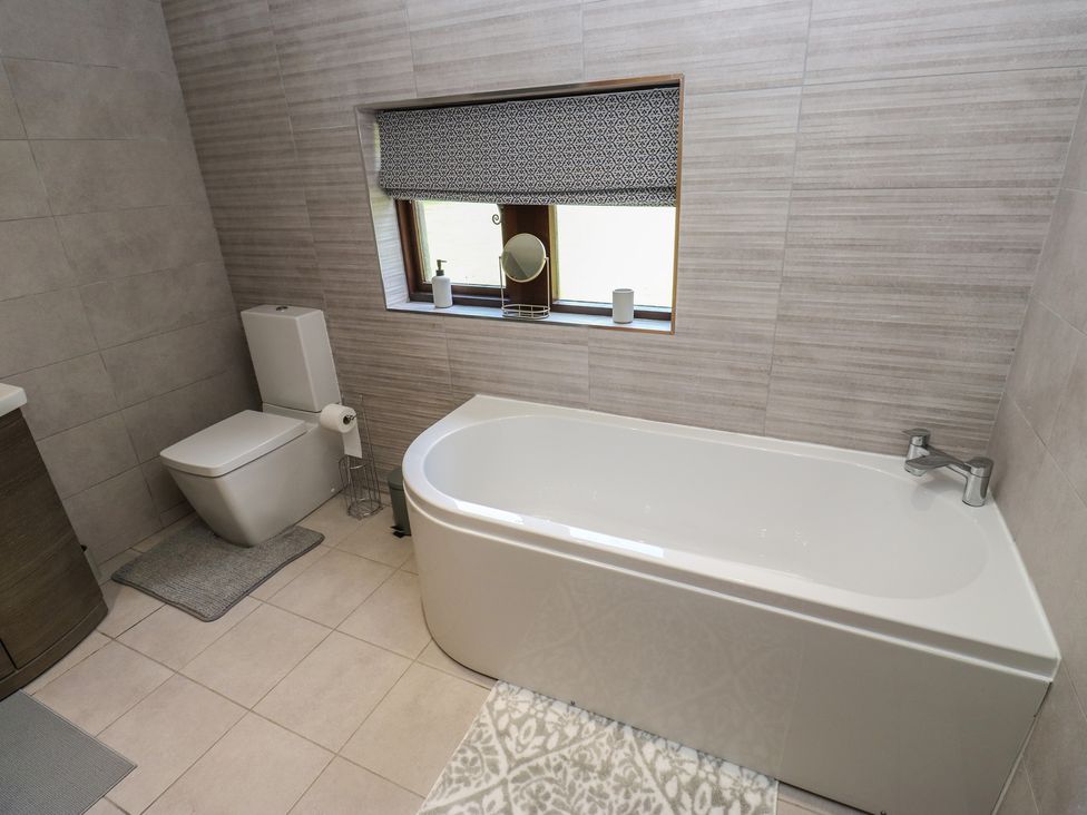 A bathroom with a bath tub and toilet at Stagwood House New Mill