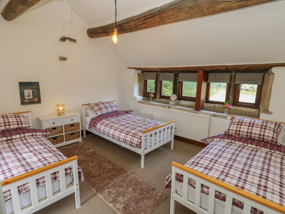 A bedroom with three beds and a nightstand at Stagwood House New Mill