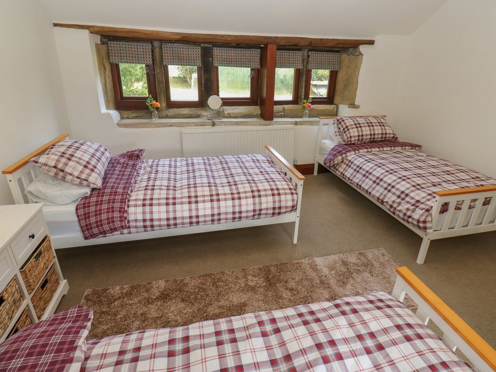 A bedroom with three beds and a window at Stagwood House New Mill