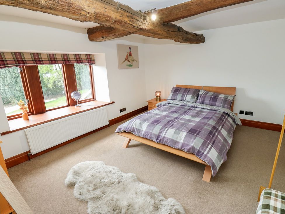 A bedroom with a bed and window at Stagwood House in New Mill