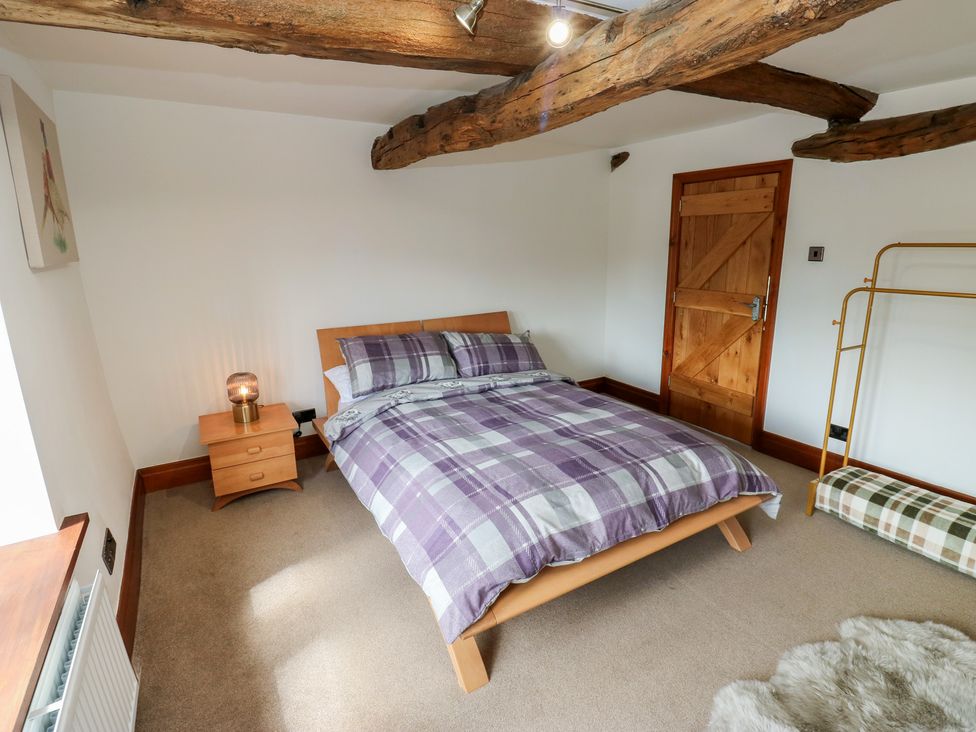 A bedroom with a bed and bedside table at Stagwood House in New Mill