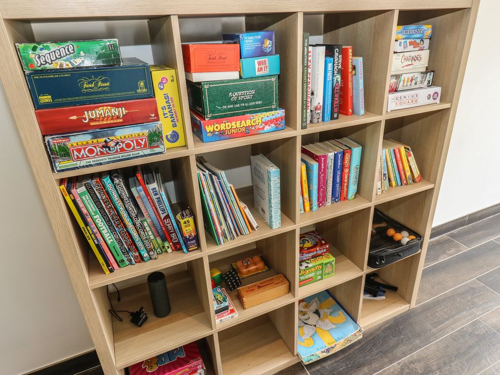 A shelving unit with board games and books at Stagwood House in New Mill